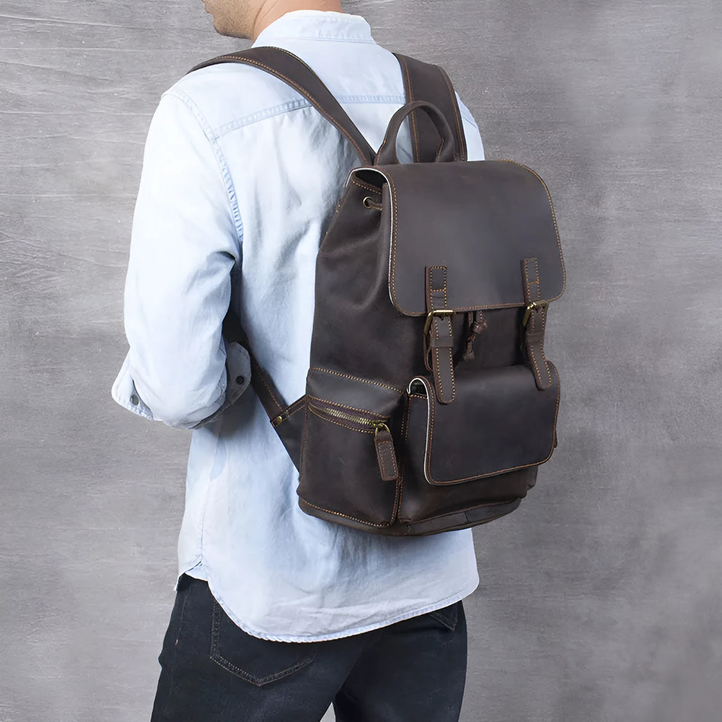 Brown leather backpack with double shoulder straps and denim lining interior