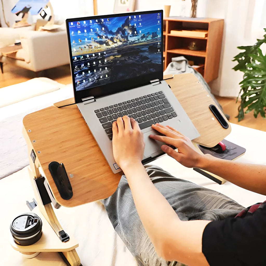 White maple wooden folding bed desk with adjustable tilted surface, holding a laptop on a duvet.