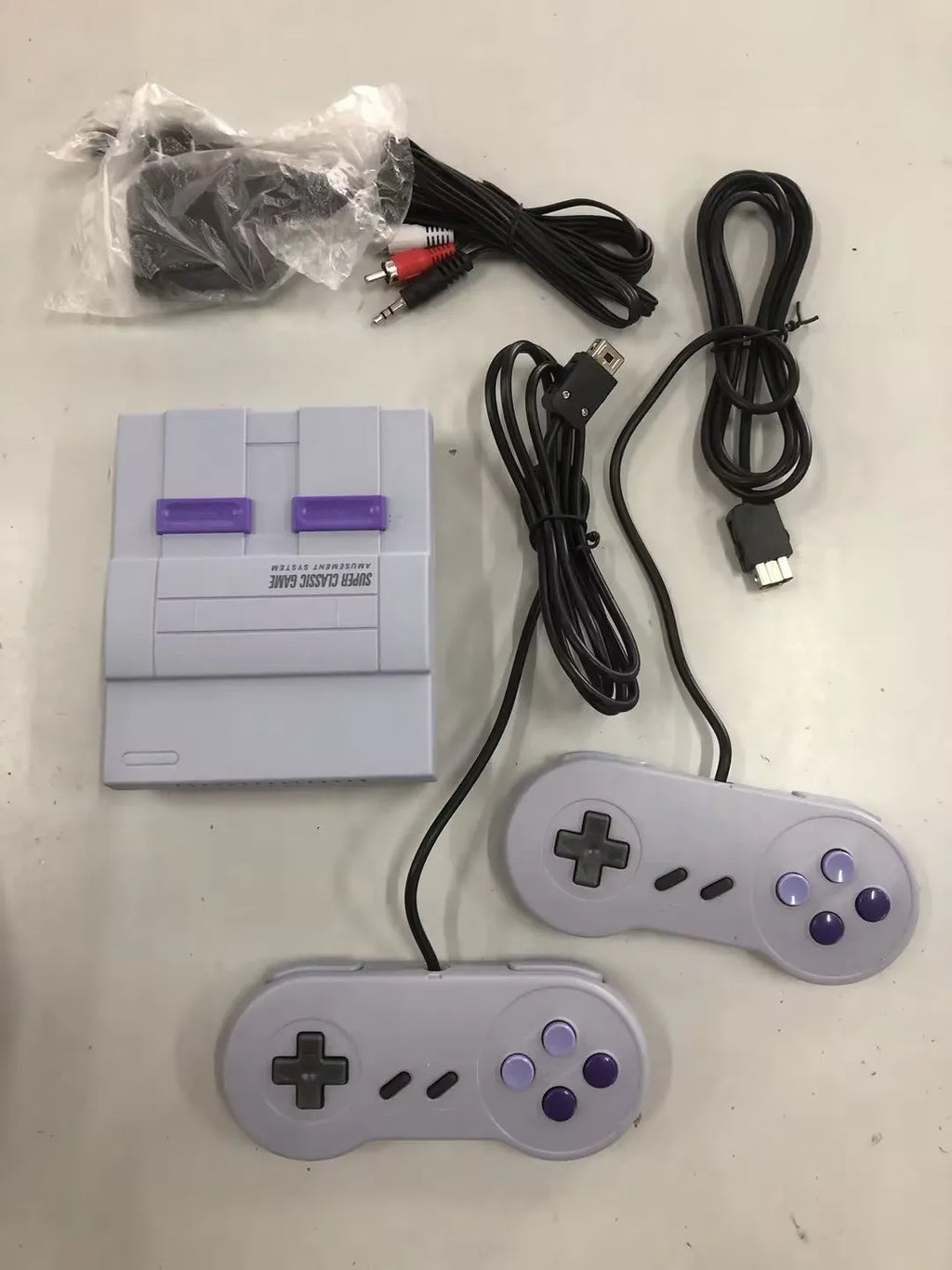 SNES mini game console replica in black with two wired controllers and HDMI cable
