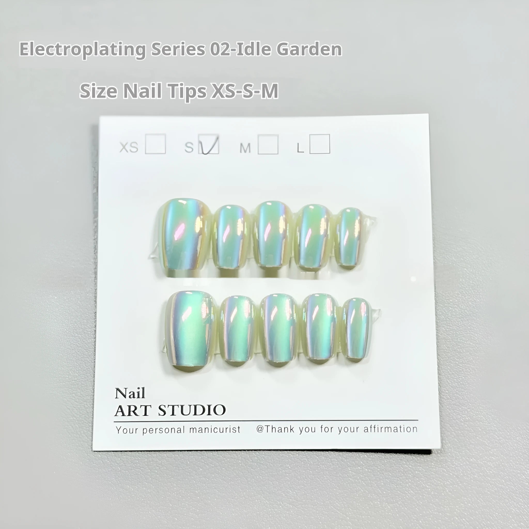 Set of electroplated Cat's Eye and aurora press-on nails in short ladder sizes on a white background.