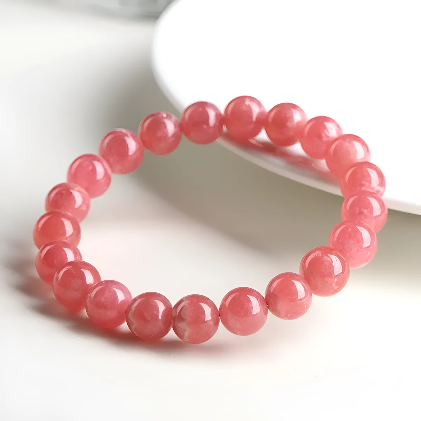 Women's crystal bracelet with a longevity lock clasp and geometric beads in rhodochrosite colours.