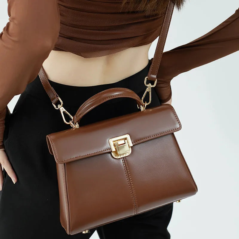 Dark brown genuine leather women's shoulder bag with a clasp, showing its horizontal square shape and shoulder strap.