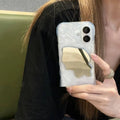 Solid colour iPhone case with water ripple texture and a small mirror, shown on a phone.