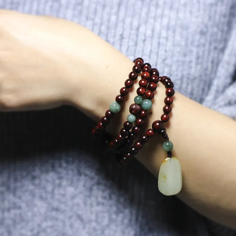 Traditional rosewood prayer bracelet with 108 beads, carved Pterocarpus santalinus decoration, and Hotian jade pendant