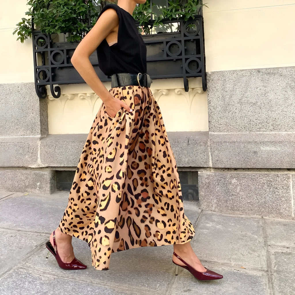 Brown leopard print women's long A-line skirt with a defined waist and wide, flowing hem on a neutral background.