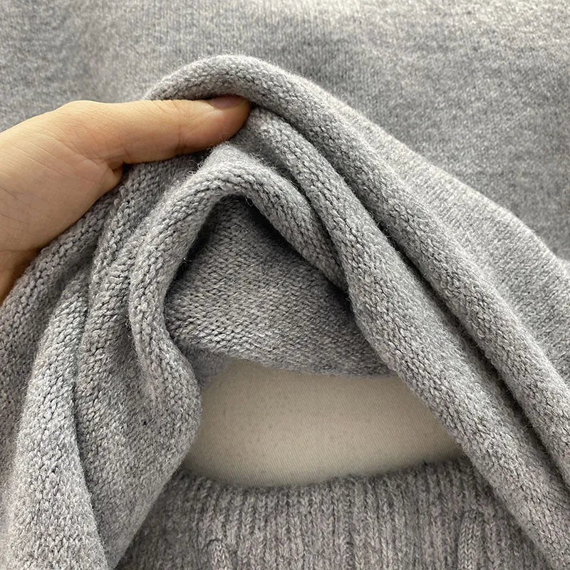 Woman wearing a loose grey knitted long sleeve sweater and matching wide-leg shorts set, front and back view.