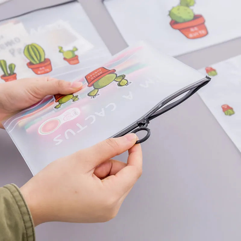Clear PVC pencil case with cactus print, sealed closure, 17.1 x 21.2 cm, containing pens and pencils