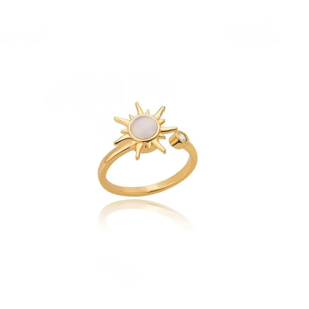 A geometric gold-coloured ring with an adjustable opening, shown rotating on a finger.