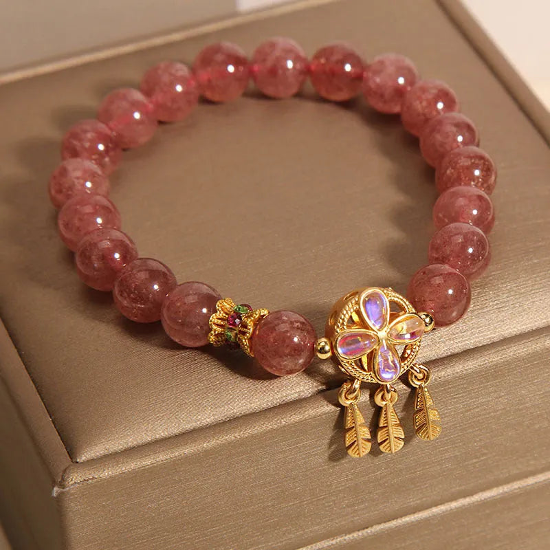 Women's strawberry quartz bracelet with a four-leaf clover dream catcher ball pendant.