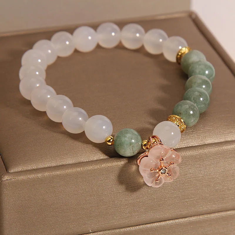 White agate floral bracelet with jade details and adjustable clasp on woman's wrist