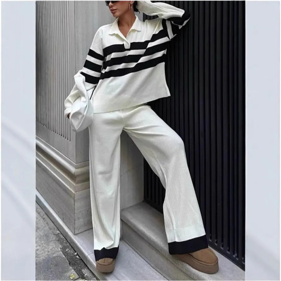 Woman wearing a black and white striped long-sleeve polo shirt and matching black casual trousers from a two-piece knit set.