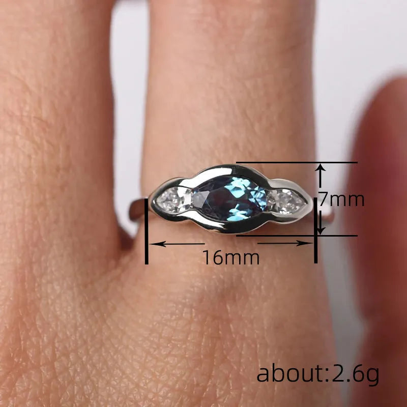 A geometric ellipse-shaped ring with an inlaid zircon, in a white gold colour finish.