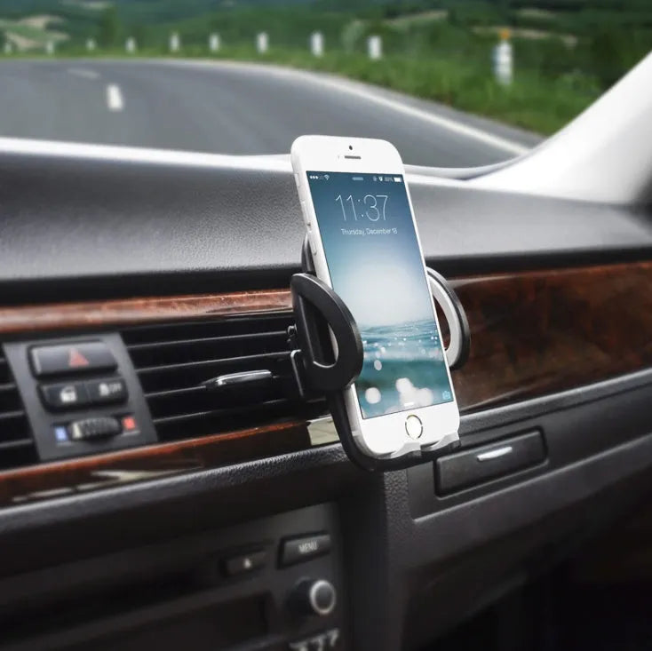 Black plastic universal mobile phone holder attached to a car air conditioning vent.