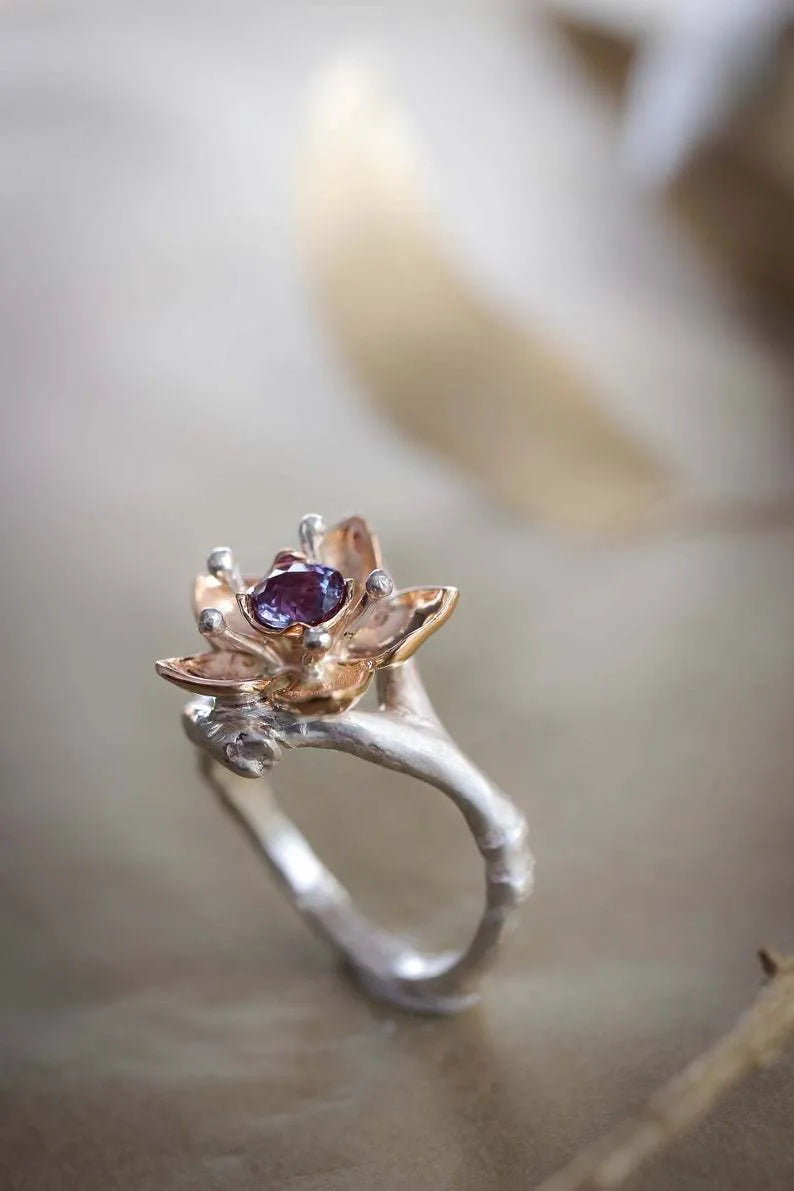 Silver two-tone women's ring with a geometric floral pattern on a white background.