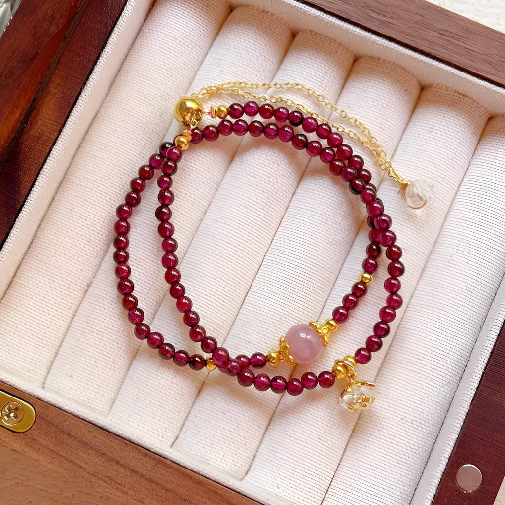 Close-up of a women's double ring bracelet made with natural garnet stones in H311 colour.