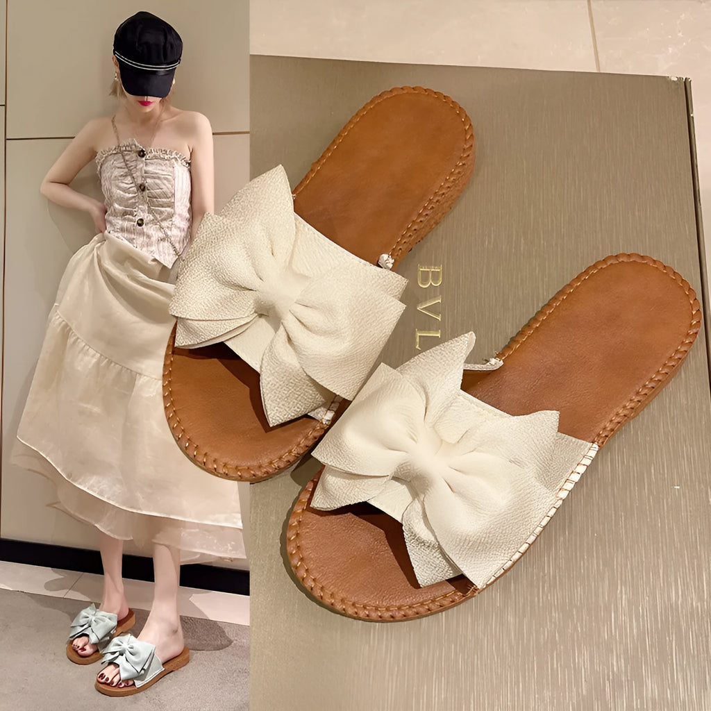 Women's beige suede slip-on sandals with bow detail and rubber sole