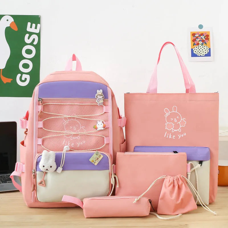 Set of four solid-colour nylon backpacks for students in pink, black, purple, and blue.