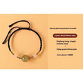 Hand-woven red rope bracelet with Hetian jade beads and assorted symbolic gold-toned charms.