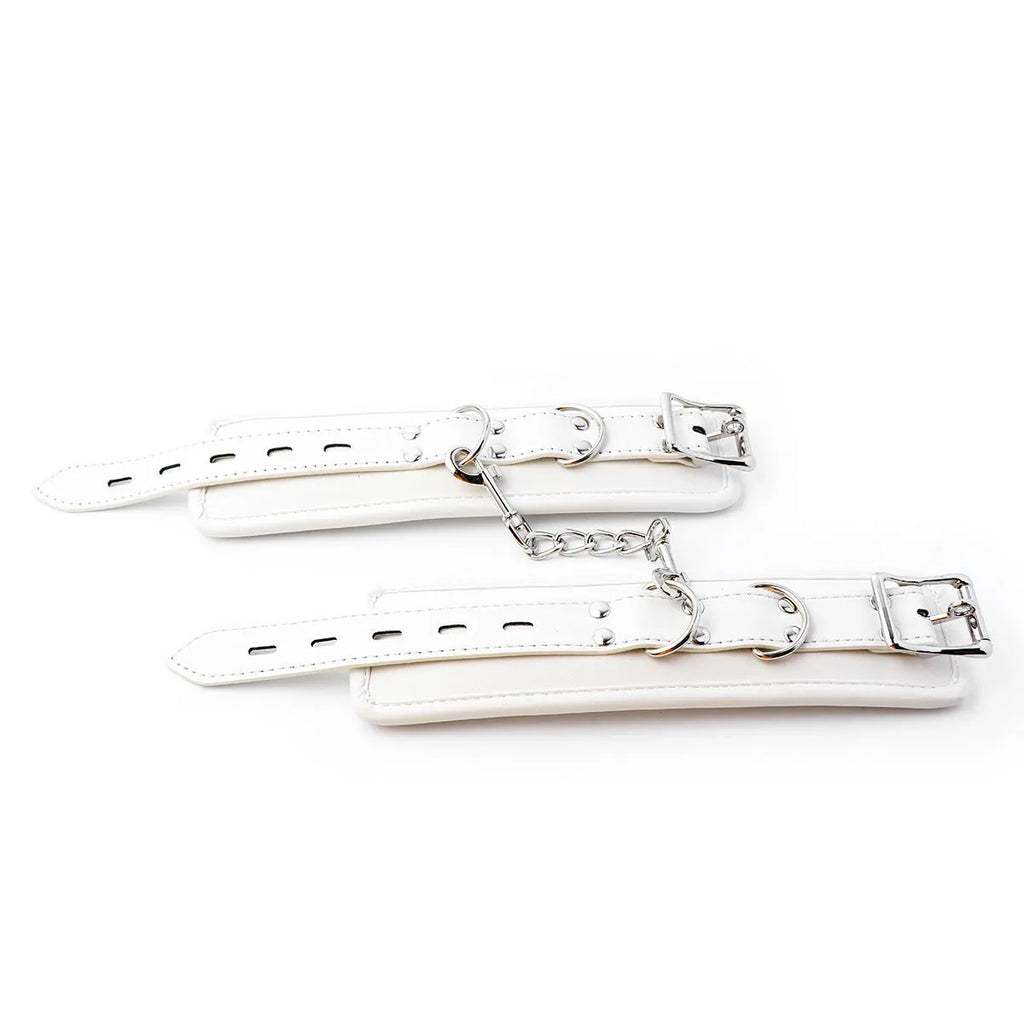 White PU sponge bondage handcuffs, foot cuffs, and neck scarf set on a plain background.