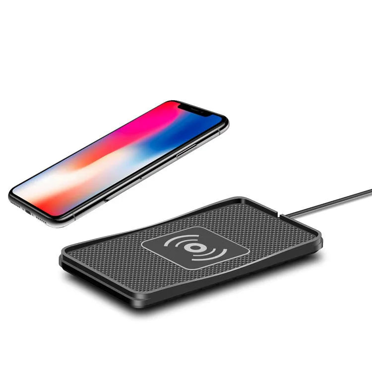Black wireless car charger with anti-slip base, shown on a car dashboard next to a mobile phone.