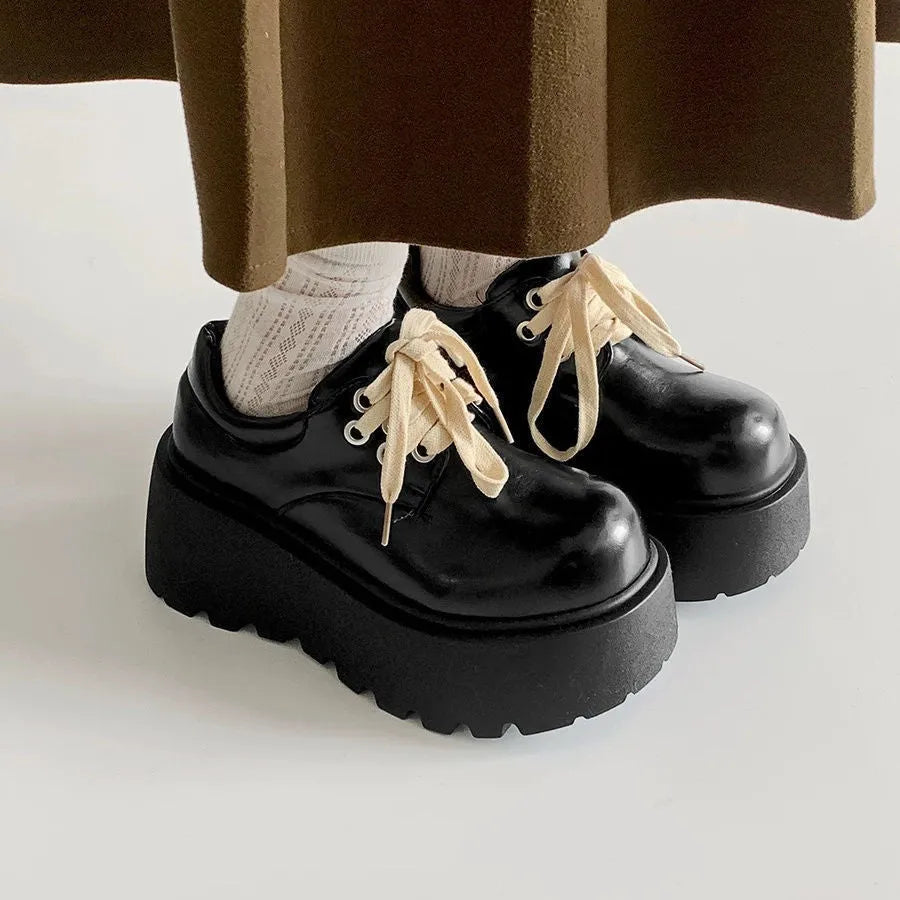 Women's matte black lace-up shoes with a thick sole and English muffin heel.