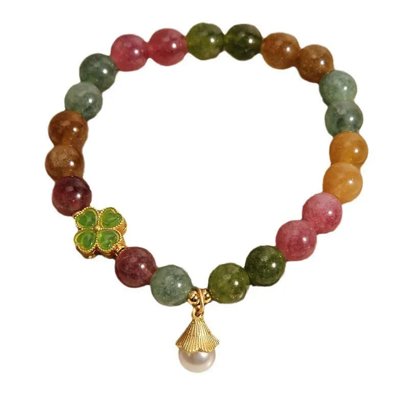 Natural colour tourmaline bracelet with four-leaf clover charm and pearl pendant on wrist