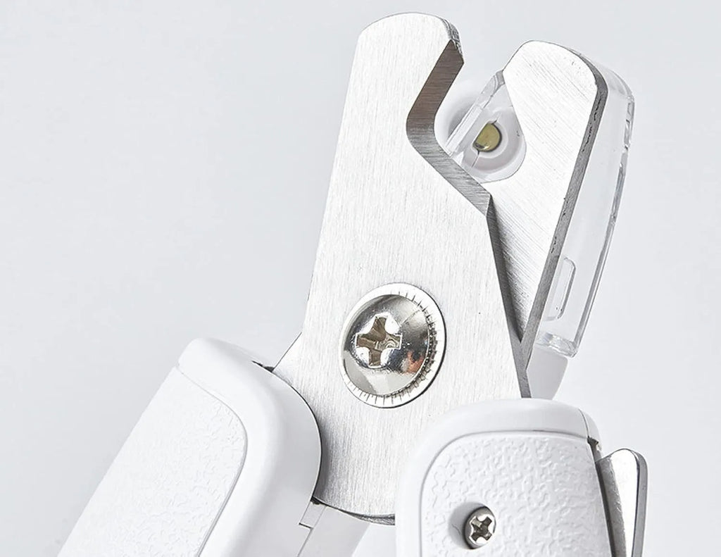 White pet nail clippers with LED light, transparent anti-splash guard, and triangular blade for cats and dogs