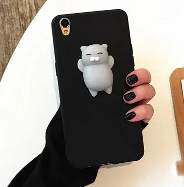 Soft silicone iPhone case with a raised 3D cartoon cat design on the back, shown in pink.