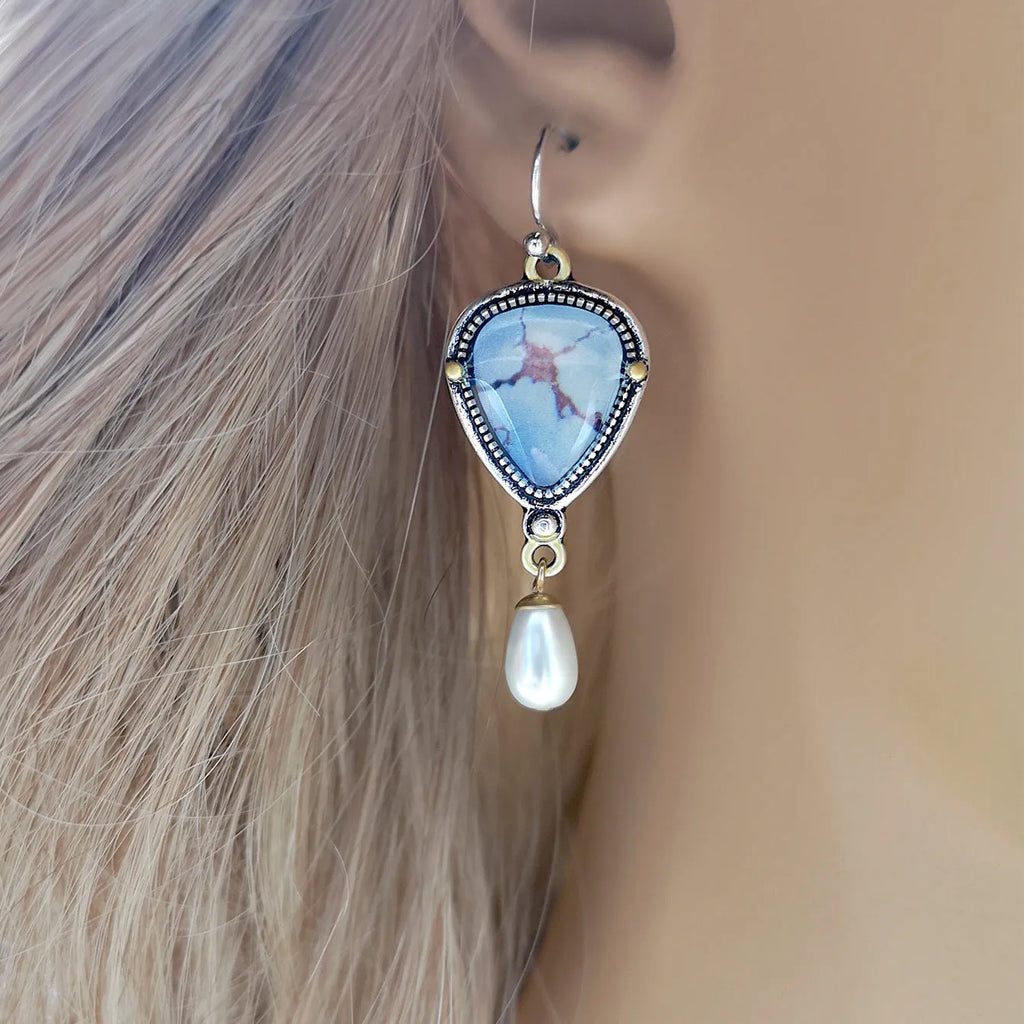 Retro blue geometric drop earrings with synthetic opal and pearl accents on white background