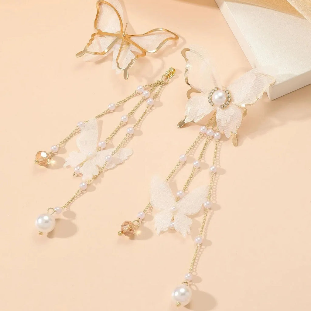 White butterfly-shaped drop earrings with rhinestones, a long chain tassel, and a pearl tip on a white background.