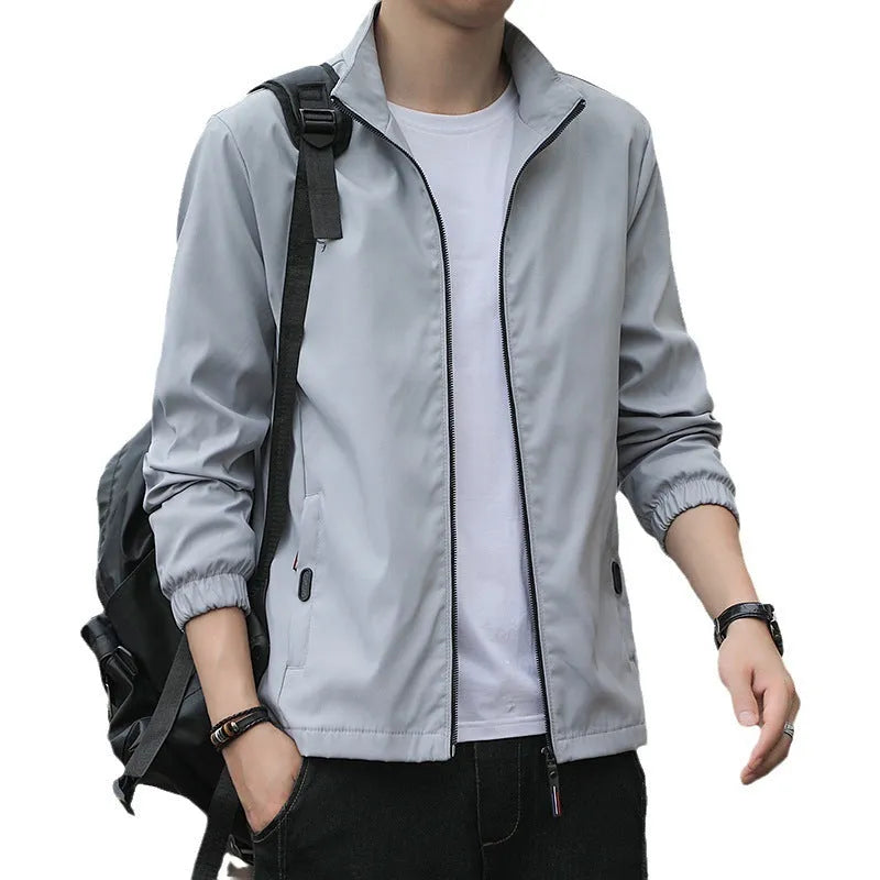 Man wearing a loose-fit grey Korean-style lapel jacket with zipper pockets.