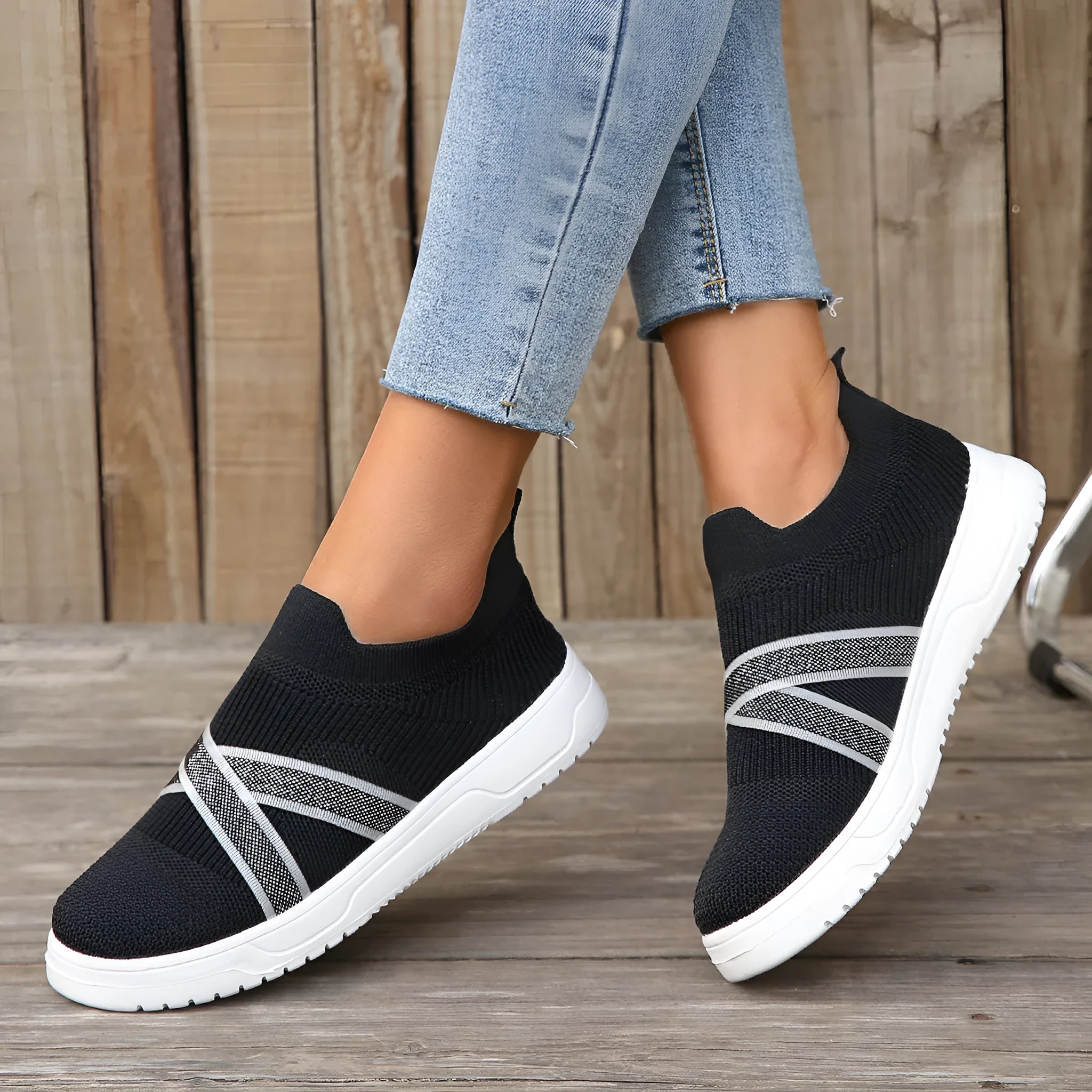Women's black flyknit mesh outdoor shoes with flat rubber sole and tassel detail.