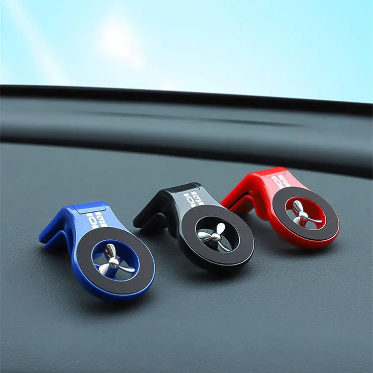 Black magnetic car phone holder mounted on a car air vent, showing 360-degree rotation and fragrance slot.