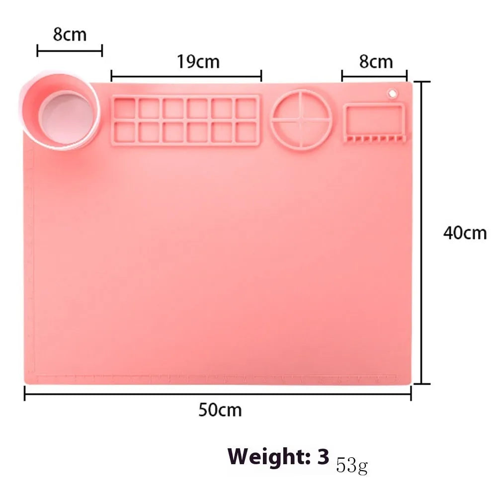 Light blue silicone painting mat measuring 50 by 40 cm on a wooden table
