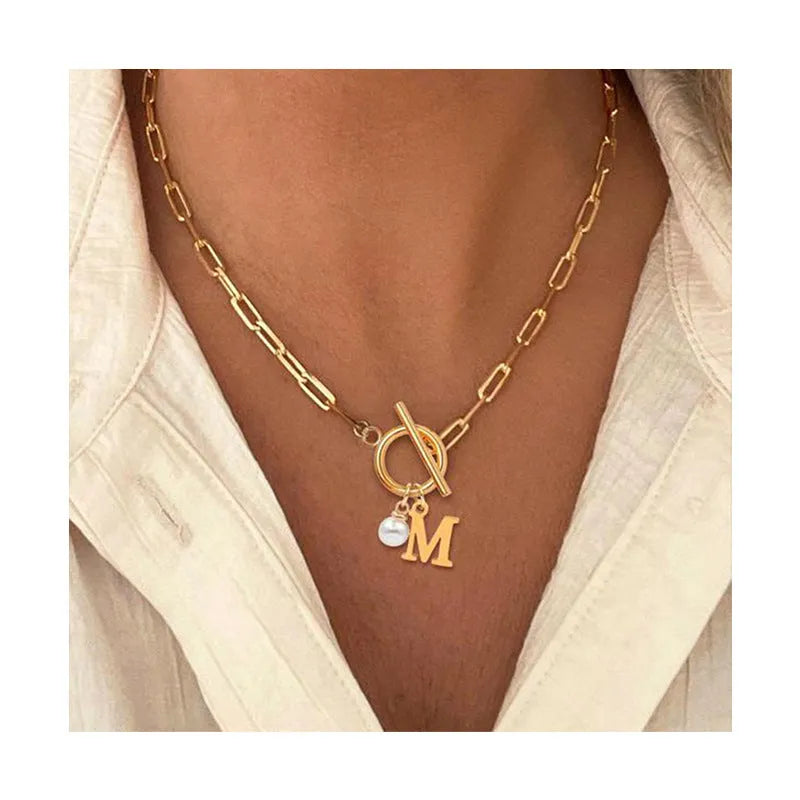 Stainless steel clip chain necklace with raised letter A pendant and imitation pearl in gold colour on a white background