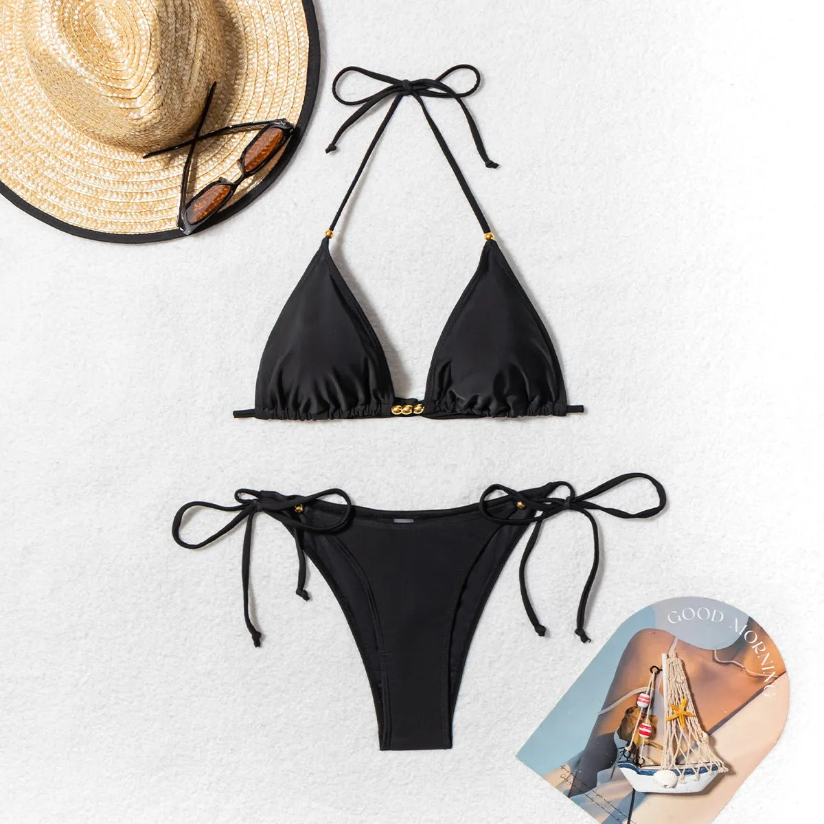 Black women's bikini swimsuit with metal bead decoration and split design.