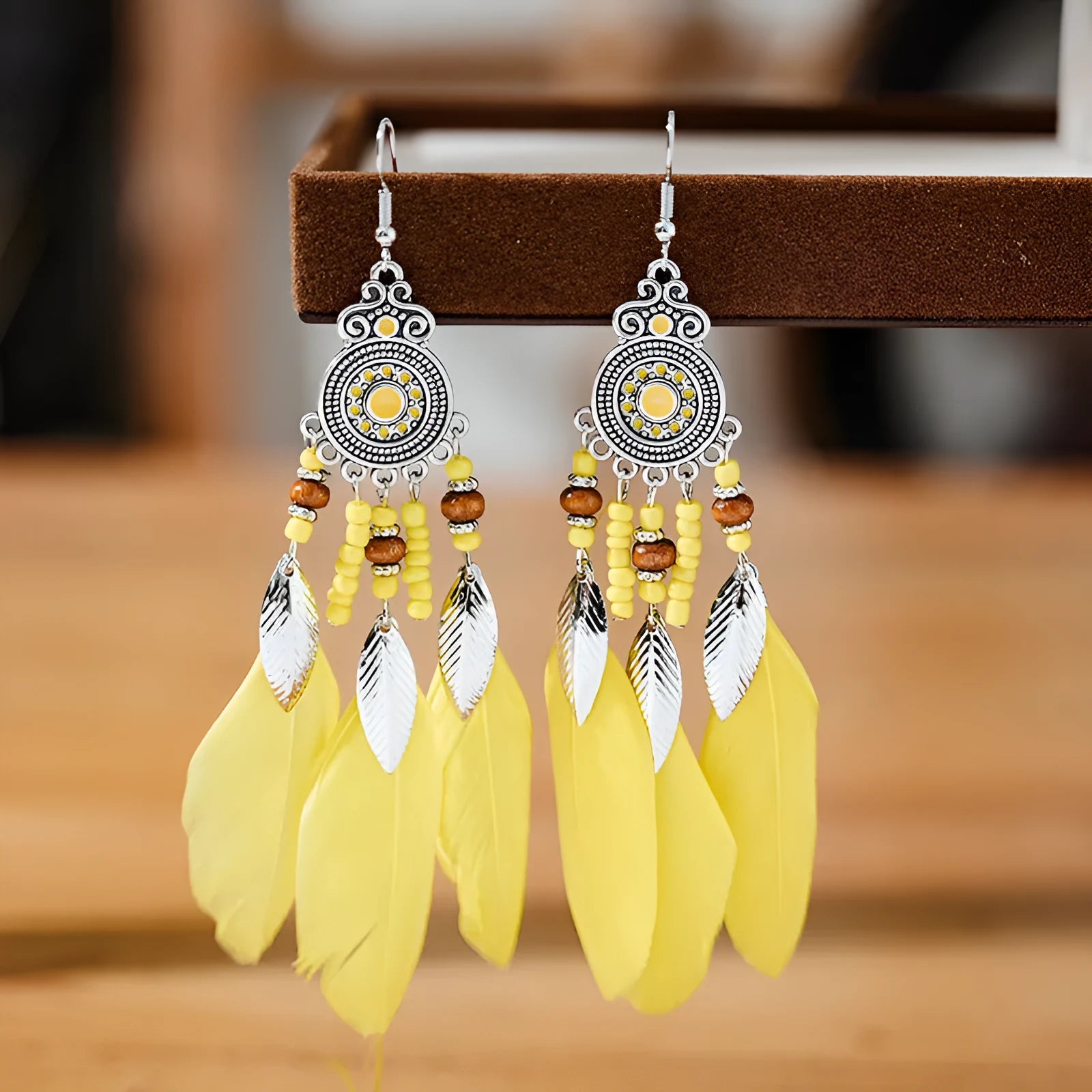 Round drop feather earrings in alloy with electroplated finish showing leaf shape and pattern details