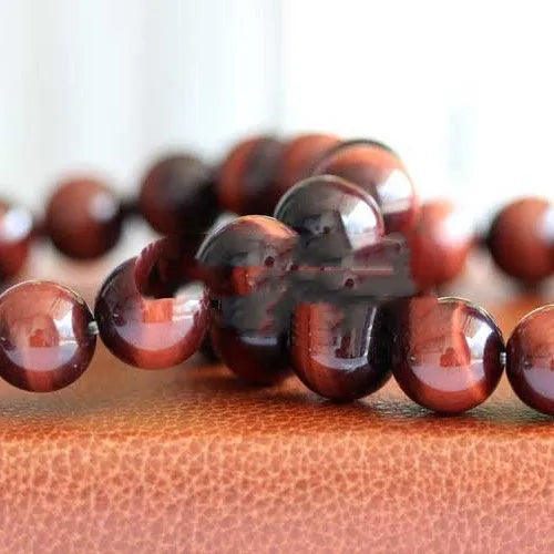 Geometric wood alexandrite bracelet with round beads showing Lightning Cat's Eye effect.