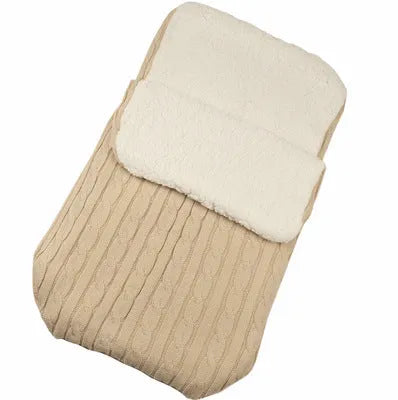 Envelope-style baby stroller sleeping bag in beige colour with thick filling, shown next to a pram.