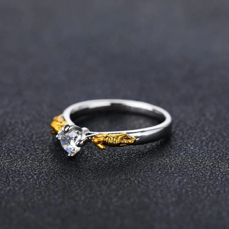 Detailed close-up of a black gold copper crown ring with a central crystal on a finger.