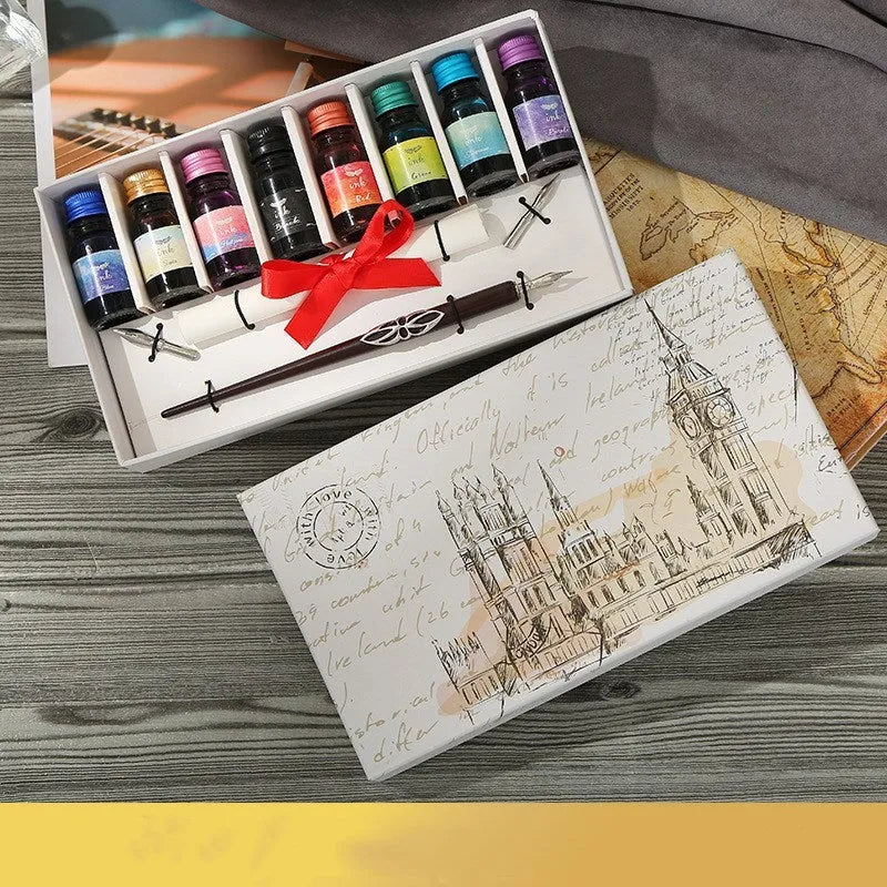 Wooden gift box open to show a wooden dip pen, standing pen holder, bottles of coloured ink, and replacement nibs.
