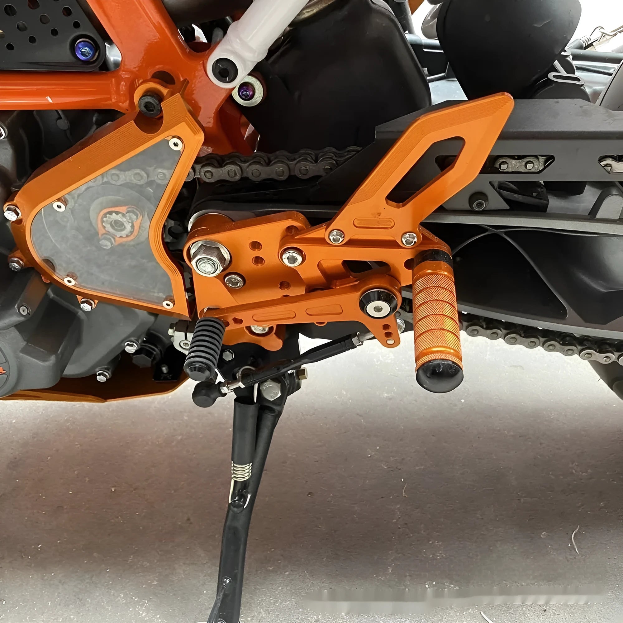 KTM DUKE motorcycle rear pedal support assembly bracket kit in black or orange
