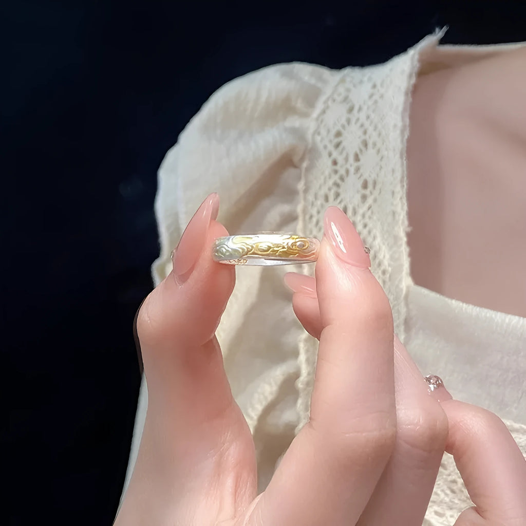 Geometric open-mouth silver and gold ring with a Xiangyun cloud pattern on a white copper band.
