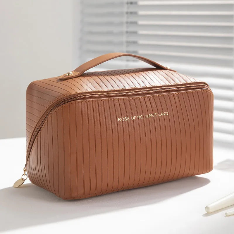 Vertical pattern pillow-shaped cubic makeup bag in PU material, shown in a neutral colour.