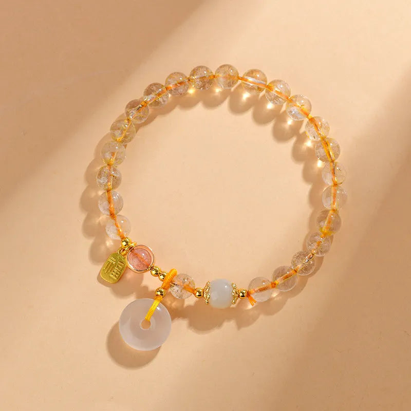 Gold rutilated quartz bracelet with safety buckle and geometric blessing card pendant.