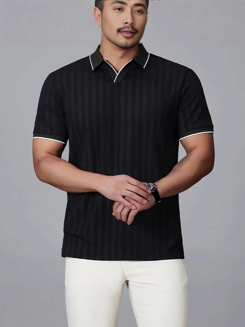 Man wearing a black loose-fit short-sleeved nylon polo shirt on a casual background.
