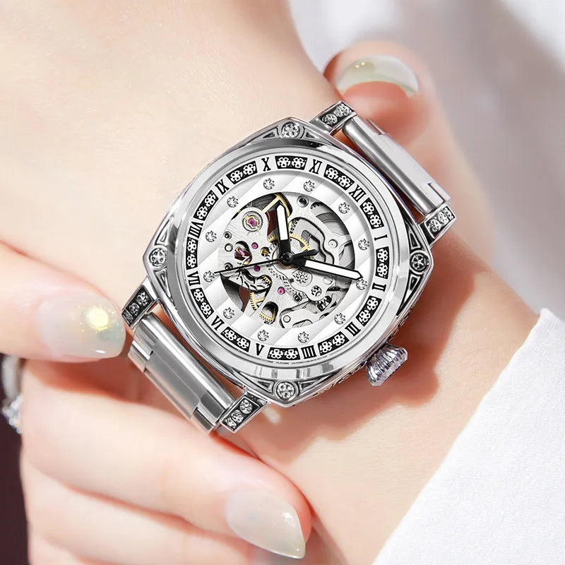 Mechanical watch with luminous hands and a black leather strap on a wrist.