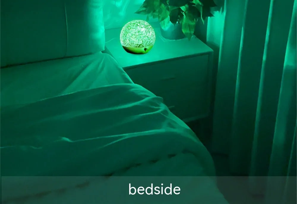 Water ripple projector night light with crystal-like acrylic body and colourful ripple patterns on a bedside table
