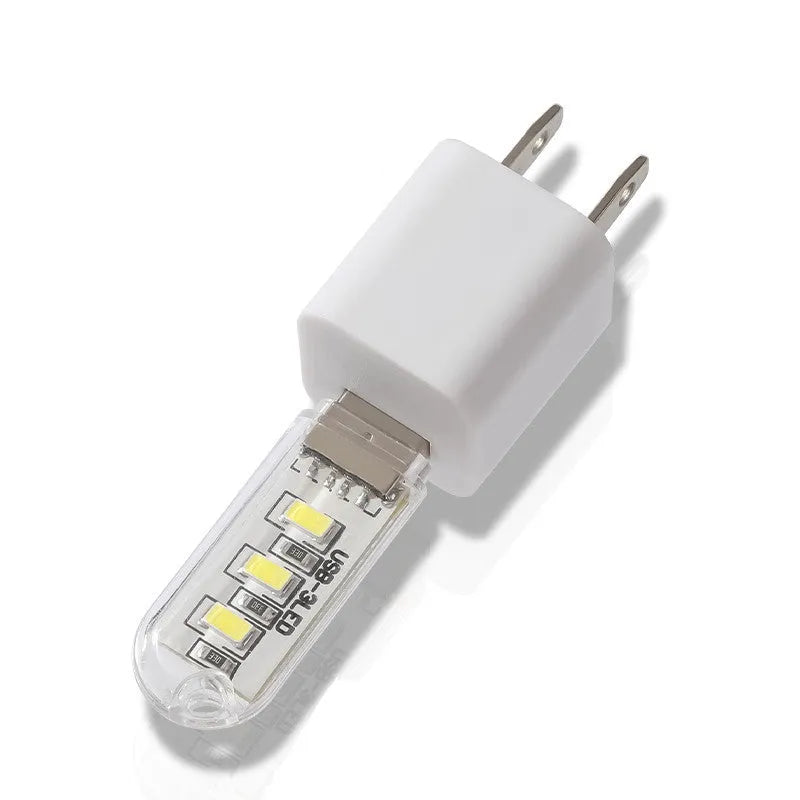 Small round white USB LED night light for nursery or bedroom on a dark surface.