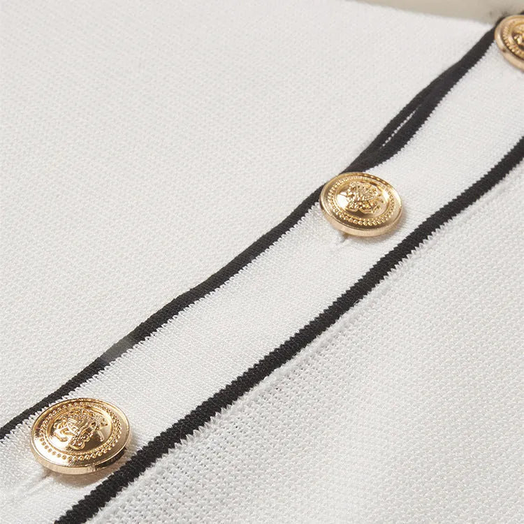 White short-sleeve cardigan with dark contrast colour lapels, buttoned front, on a hanger.